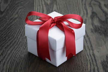 gift box with red bow on rustic table
