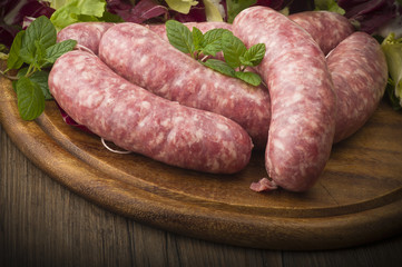 raw homemade sausage on a wooden board - obrazy, fototapety, plakaty
