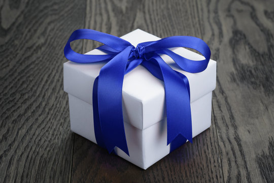 Gift Box With Blue Bow On Rustic Table