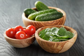tomatoes and cucumbers in bowl on wood table