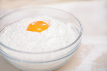 Small glass bowl filled with flour and yolk.