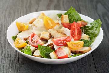 caesar salad with chiken fillet and different color tomatoes