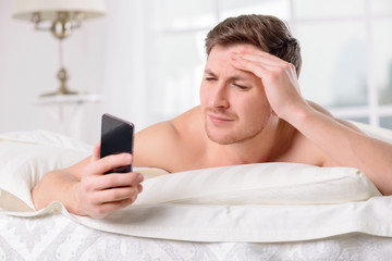 Guy checks his social networks after awakening. 