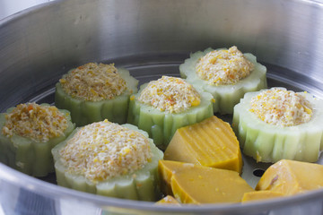 pumpkin and bitter melon stuffed with vermicelli, tofu, corn and carrot while steaming in steaming...