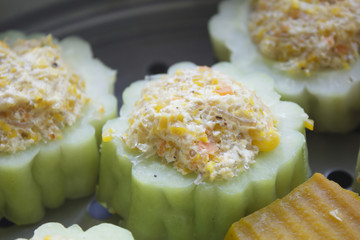 bitter melon stuffed with vermicelli, tofu, corn and carrot while steaming in steaming pot...