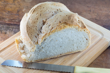 Pane calabrese in primo piano, pane fatto in casa, pane su tagliere, brutto e buono, pane da affettare  su tagliere con coltello