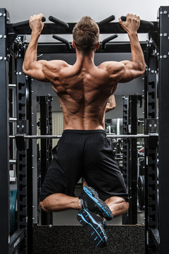 Muscular man training his back