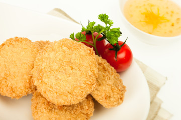 Fried coated cutlets with cherry tomatoes in a bowl