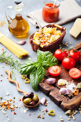 Italian food , tomatoes, basil, spaghetti, olives, parmesan.