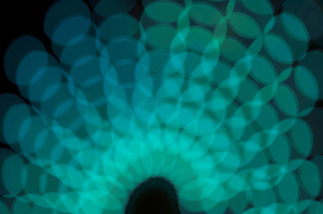Defocused turquoise circles at night. Bokeh background.