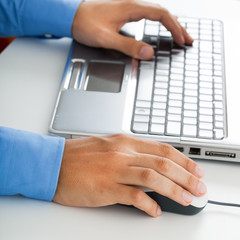 Closeup of business man hand typing on laptop keyboard