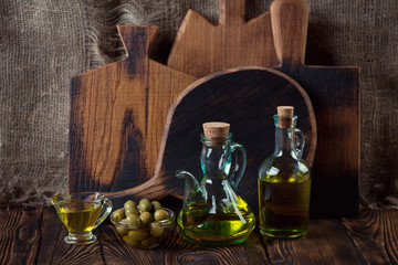 Obraz na płótnie Canvas Glass bottles with olive oil and green olives, studio shot