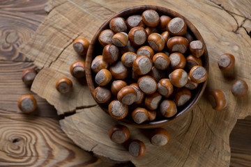 Above view of a wooden bowl with hazelnuts, studio shot