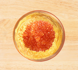 Delicious pancakes with red caviar on wooden table