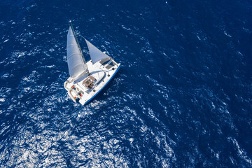 Obraz premium Amazing view to Catamaran cruising in open sea at windy day. Drone view - birds eye angle