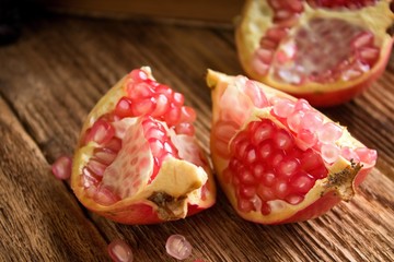 Three pieces of pomegranate on plank board