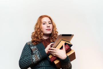 studio shot of redhead girl with books and tablet. Education concept