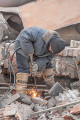 Welder using cutting torch to cut a rail