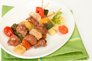 Fried barbeque meat on a bamboo sticks with vegetables