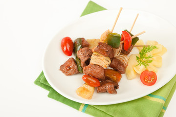 Fried barbeque meat on a bamboo sticks with vegetables