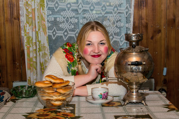 Woman in traditional scarf drinking tea.