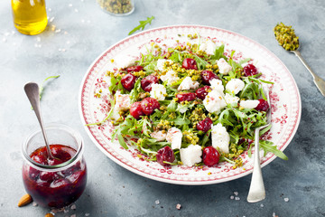 Salad with arugula, cherries and goat cheese.
