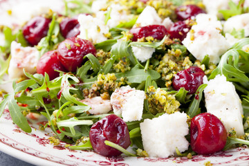 Salad with arugula, cherries and goat cheese.