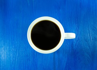 Cup of black coffee isolated on blue wooden background 