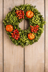 Autumn door wreath on wooden background
