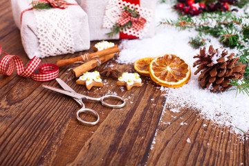 Handmade gift boxes near Christmas tree with cookies and spices.