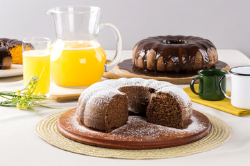 Chocolate cake on the table with carrot cake in the background.