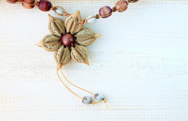 Artisan cuban necklace accessories handmade from natural materials - melon seeds and twine. Wooden backdrop. 