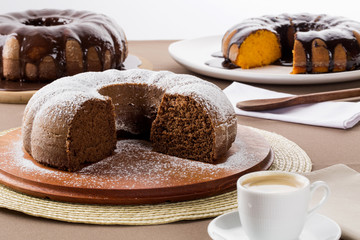 Chocolate cake on the table with carrot cake in the background.