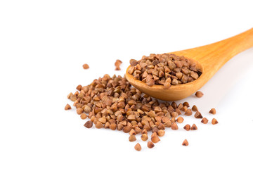 Uncooked buckwheat on wooden spoon
