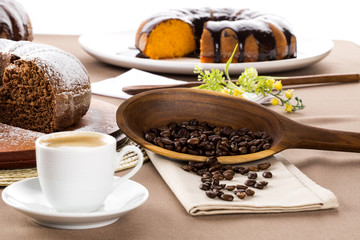 Chocolate cake on the table with cooffe in the background.