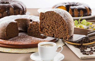 Chocolate cake on the table with carrot cake in the background.