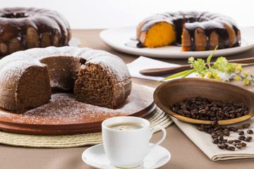 Chocolate cake on the table with carrot cake in the background.