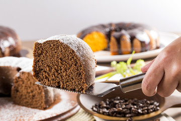 Chocolate cake on the table with carrot cake in the background.