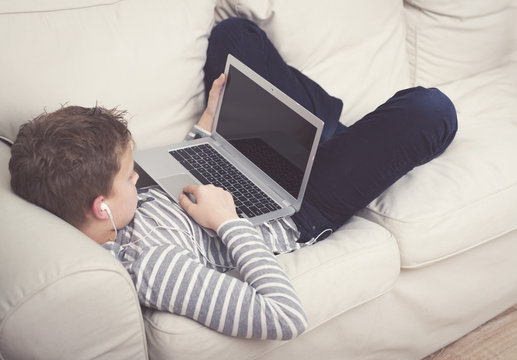 Young boy relaxing with a laptop computer