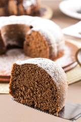 Chocolate cake on the table with carrot cake in the background.
