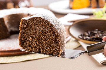 Chocolate cake on the table with carrot cake in the background.