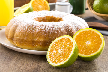 Orange cake on the table with fruits and juice.