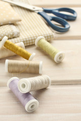 Fototapeta na wymiar Fabrics and threads on wooden table