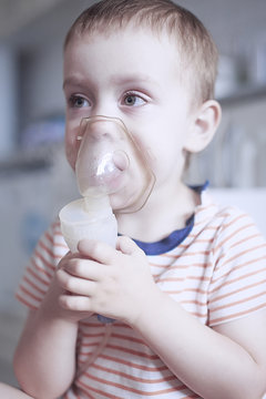 Inhalation By Nebulizer. A Child In A Mask By A Nebulizer For Inhalation During Asthmatic Attack. Medical Therapy If Difficulty Breathing, Asthma, Respiratory Diseases