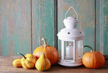 White lantern and colorful pumpkins on wooden table © agneskantaruk