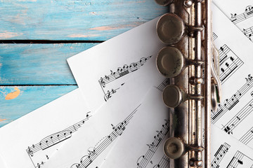 Old flute with sheet music on blue wooden boards © Zerophoto
