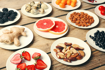 Different products on saucers on wooden table close up