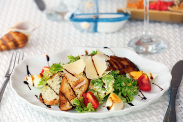 Tasty salad with wine on white served table