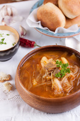 Redbeet soup with mushrooms and bread on a rustic background.