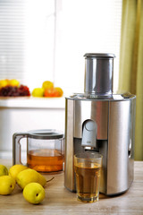 Juicer and pear juice on kitchen table